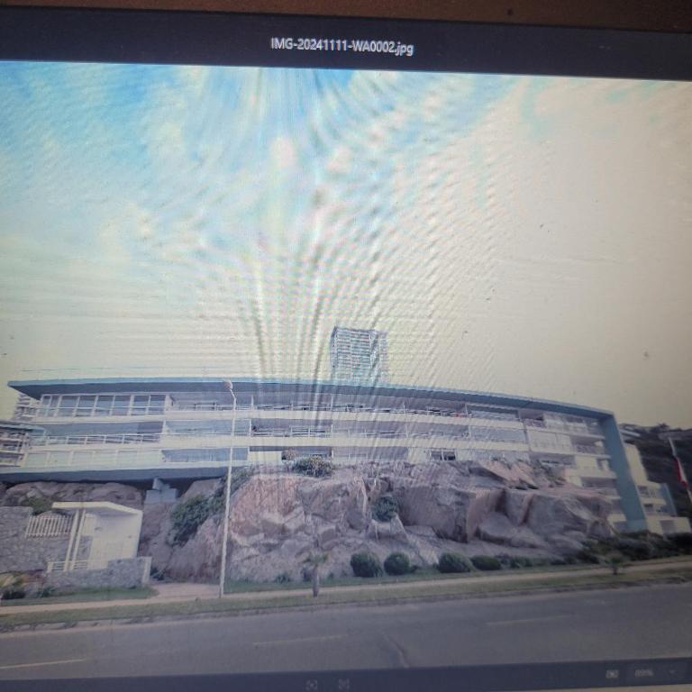 ein Bild eines Gebäudes mit einem Berg in der Unterkunft Departamento vista al Mar, Costa Lilenes Concon in Valparaíso