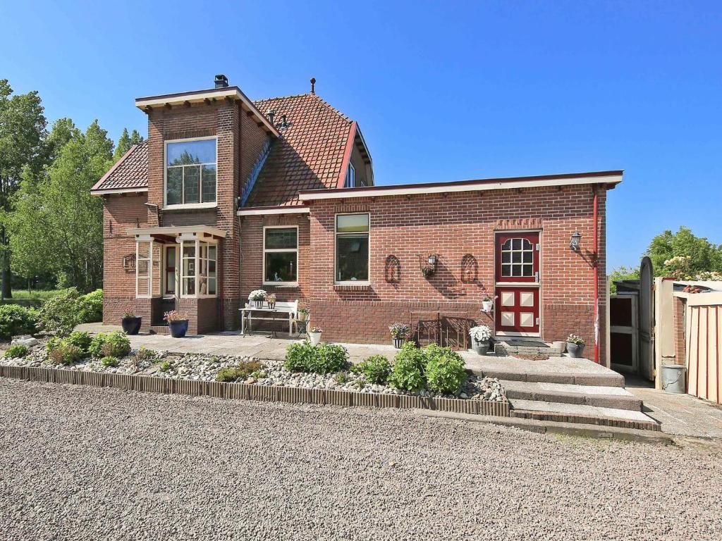 a brick house with a patio and a driveway at Characteristic country house with wellness in Lijnden