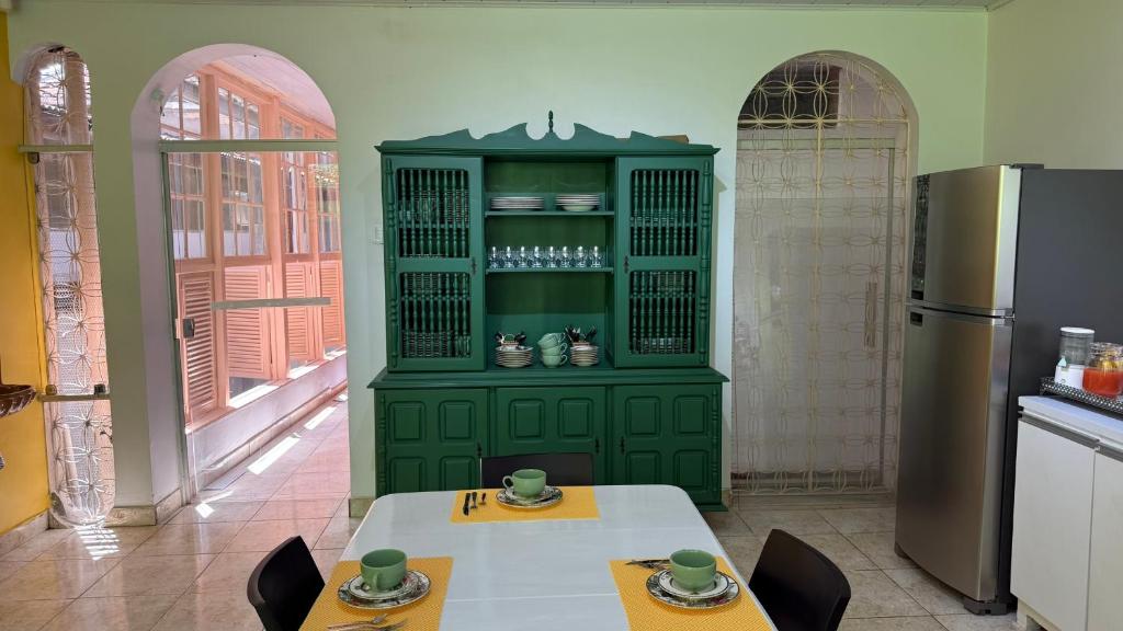 een groene kast in een keuken met een tafel en stoelen bij Mangueirosa Hostel in Belém
