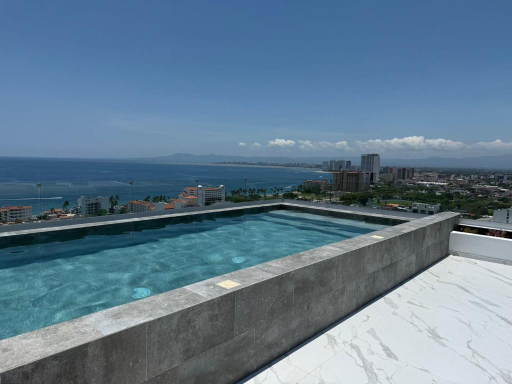 a swimming pool on the roof of a building at Modern 2BR Ocean view - Walk to Beach and Downtown in Puerto Vallarta