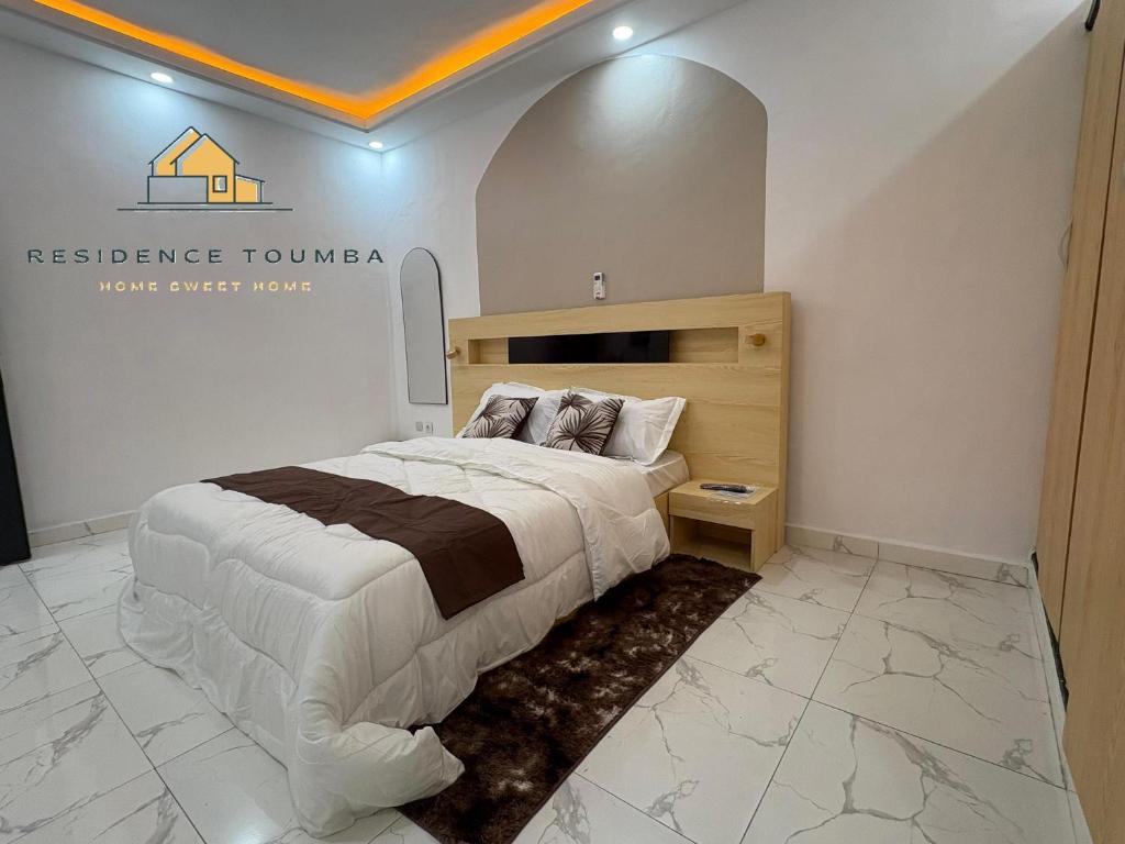 una camera da letto con un letto e un cartello sul muro di luxury a Abidjan