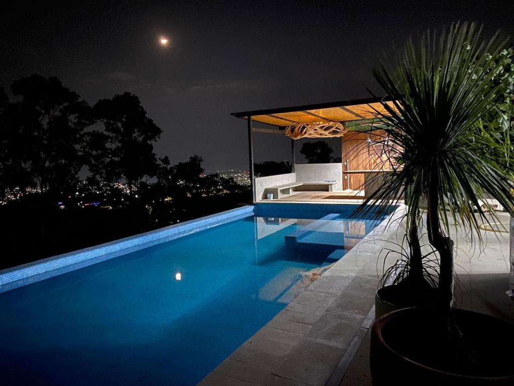 a blue swimming pool at night with a house at Spectacular Igloo-style House in Oaxaca City