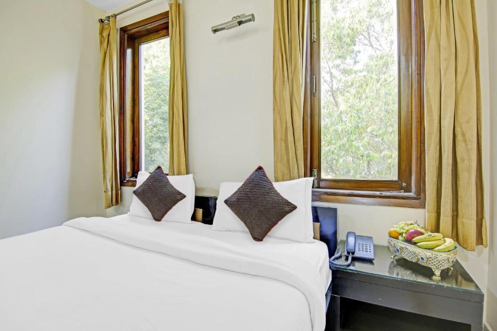 two white beds in a room with a window at Collection O Imperial Oak Near Leisure Valley Park in Gurgaon
