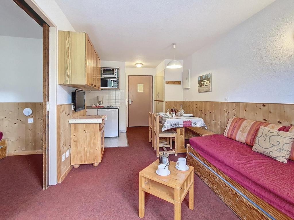 a living room with a couch and a kitchen at Les Menuires : Appartement cosy pour 4 pers avec WIFI - FR-1-344-1225 in Les Bruyères