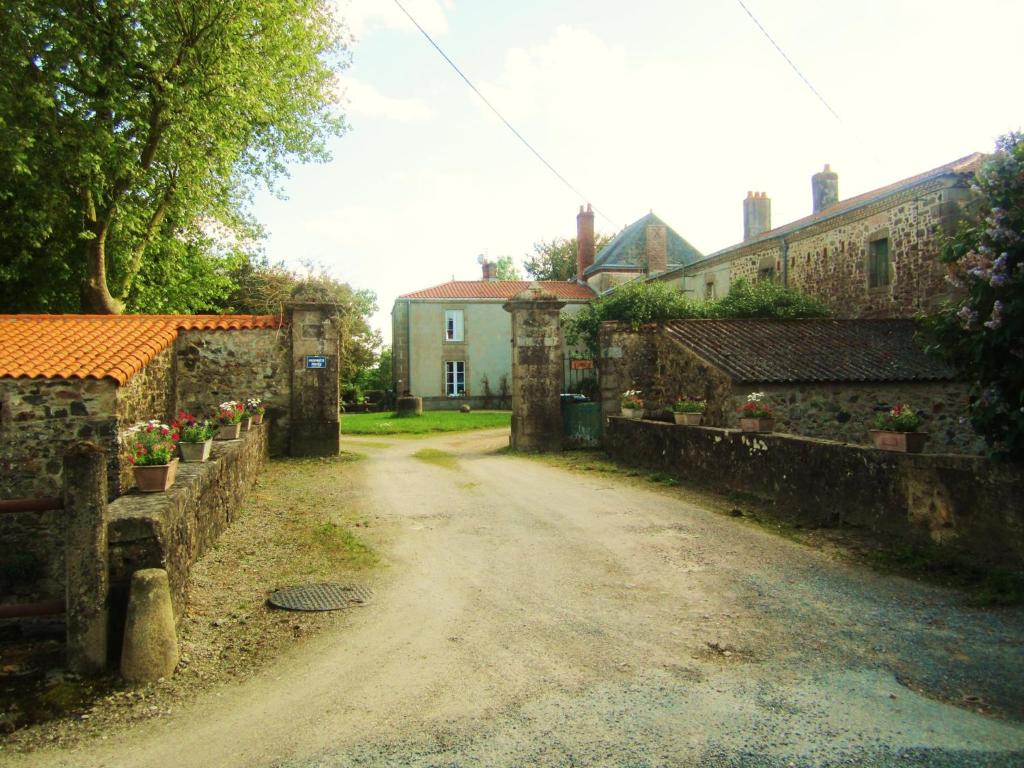 eine unbefestigte Straße in einem Dorf mit einigen Gebäuden in der Unterkunft Le Manoir "Aux Douves" in Bazoges-en-Paillers