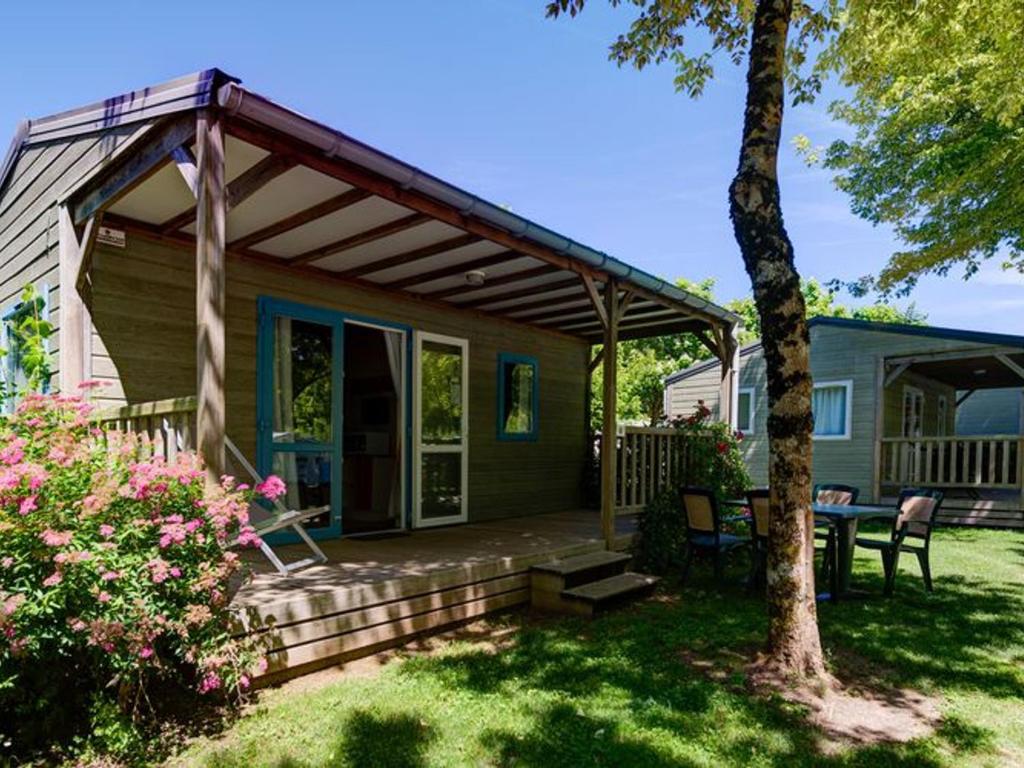 a porch of a house with a table and chairs at Chalet avec Terrasse à Coulon, 36m², 5 personnes - API-1-52-569 in Coulon