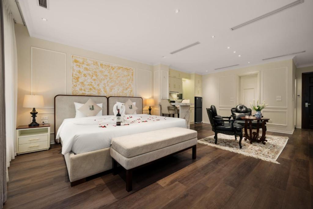 a bedroom with a large bed and a table and chairs at Jade Boutique Hotel in Hanoi