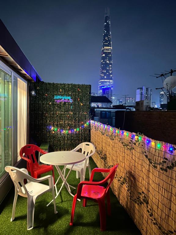 ソウルにあるShiny Picnicの街のスカイラインが見えるバルコニーに置かれたテーブルと椅子