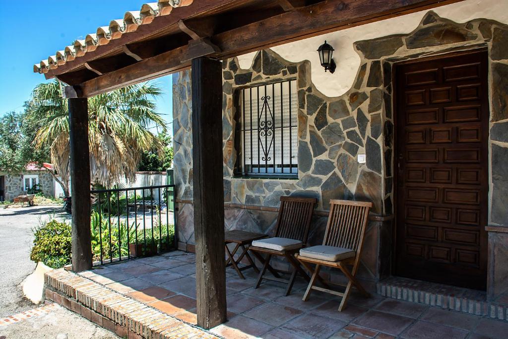 a patio with two chairs and a building with a door at Complejo Vacacional Los Cortijillos-Solo adultos in Conil de la Frontera