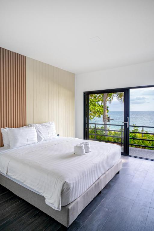 a bedroom with a large bed with a view of the ocean at Pine Bungalow Krabi in Klong Muang Beach