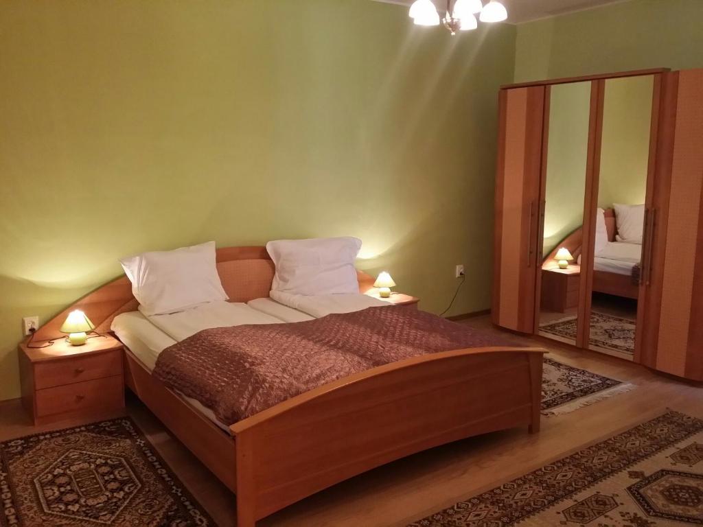 1 dormitorio con 1 cama grande y espejo en Anda Residence, en Sibiu