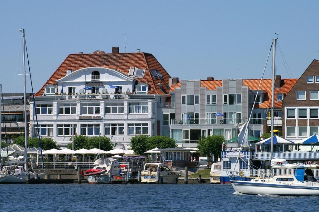 a boat in the water in front of a large building at Hotel Deutscher Kaiser in Travemünde