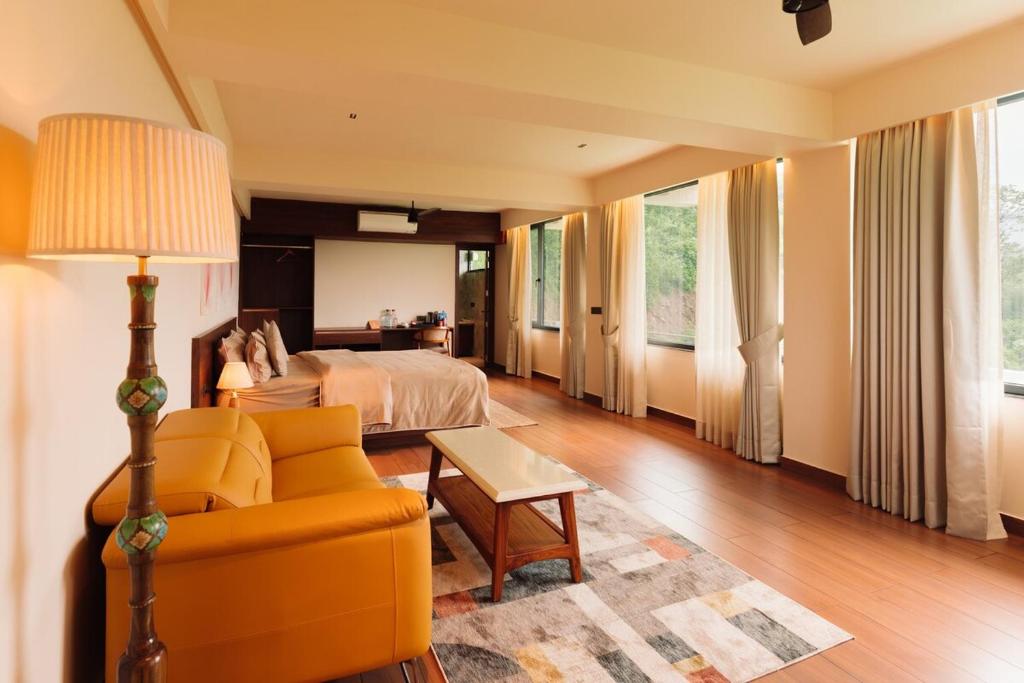 a bedroom with a bed and a couch and a table at THE EDGE Kasauli in Kasauli