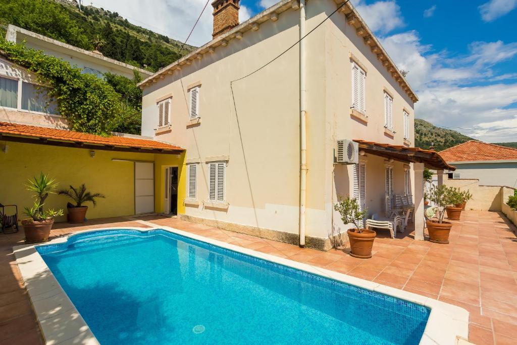 a villa with a swimming pool in front of a house at Central Apartment in Dubrovnik