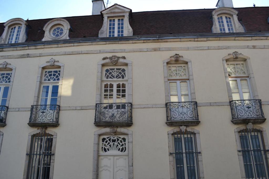 un edificio blanco con ventanas y techo marrón en Les Charmottes, en Nuits-Saint-Georges