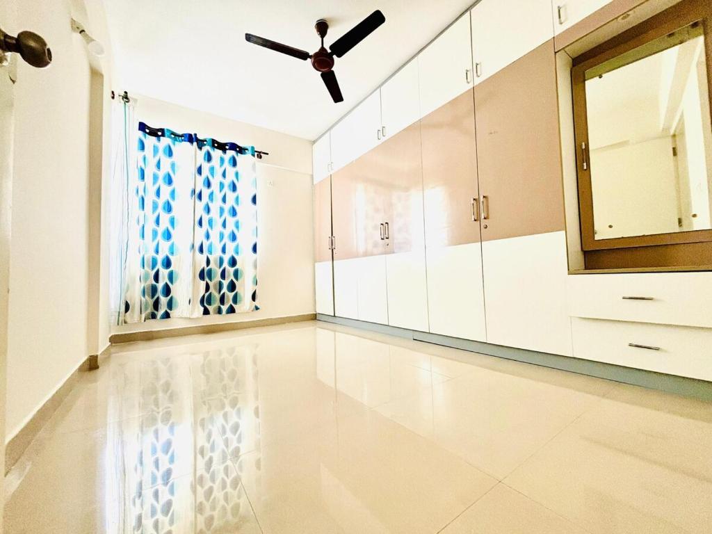 an empty room with a ceiling fan and a window at Home Stay 1 BHK Apartment Electronic City -Oakwood in Attibele