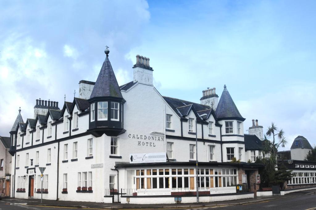 a large white building on the side of a street at Caledonian Hotel 'A Bespoke Hotel’ in Ullapool