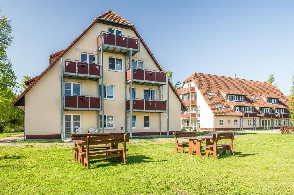 un edificio con mesas y bancos delante de él en BSW-Ferienwohnungen Zingst, en Zingst