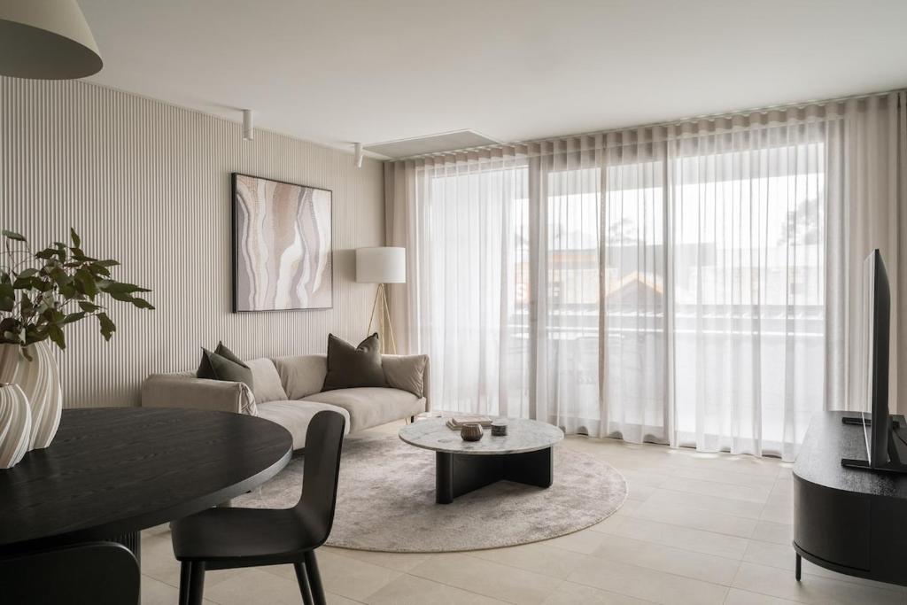 una sala de estar con un sofá y una mesa en Terra Suite - Central Dunsborough Luxury Apartment, en Dunsborough