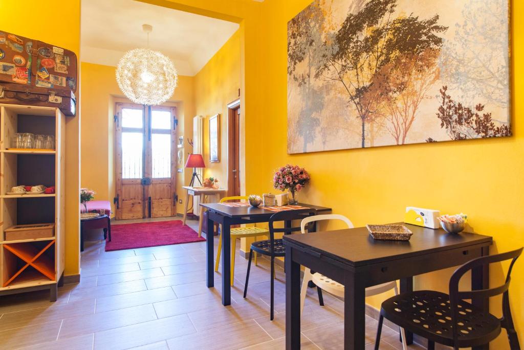 un comedor con 2 mesas y una pared amarilla en La Casermina, en Pisa