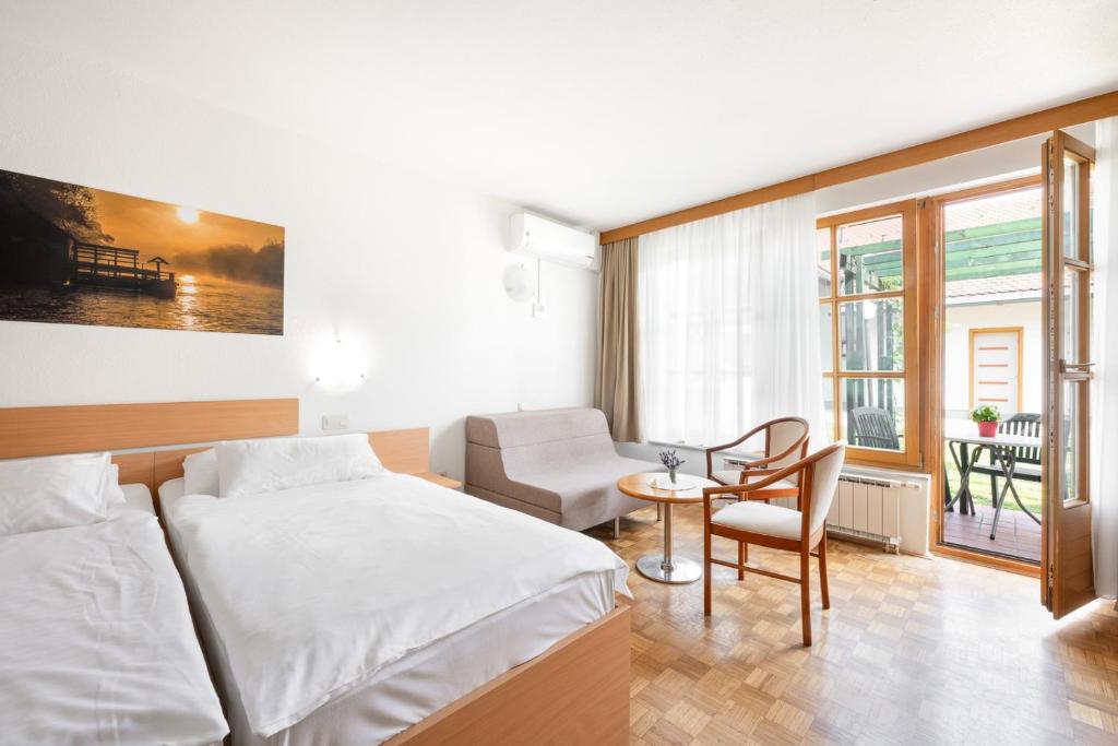 a bedroom with a bed and a table and a chair at Terme Banovci - Hotelsko naselje Zeleni gaj in Banovci