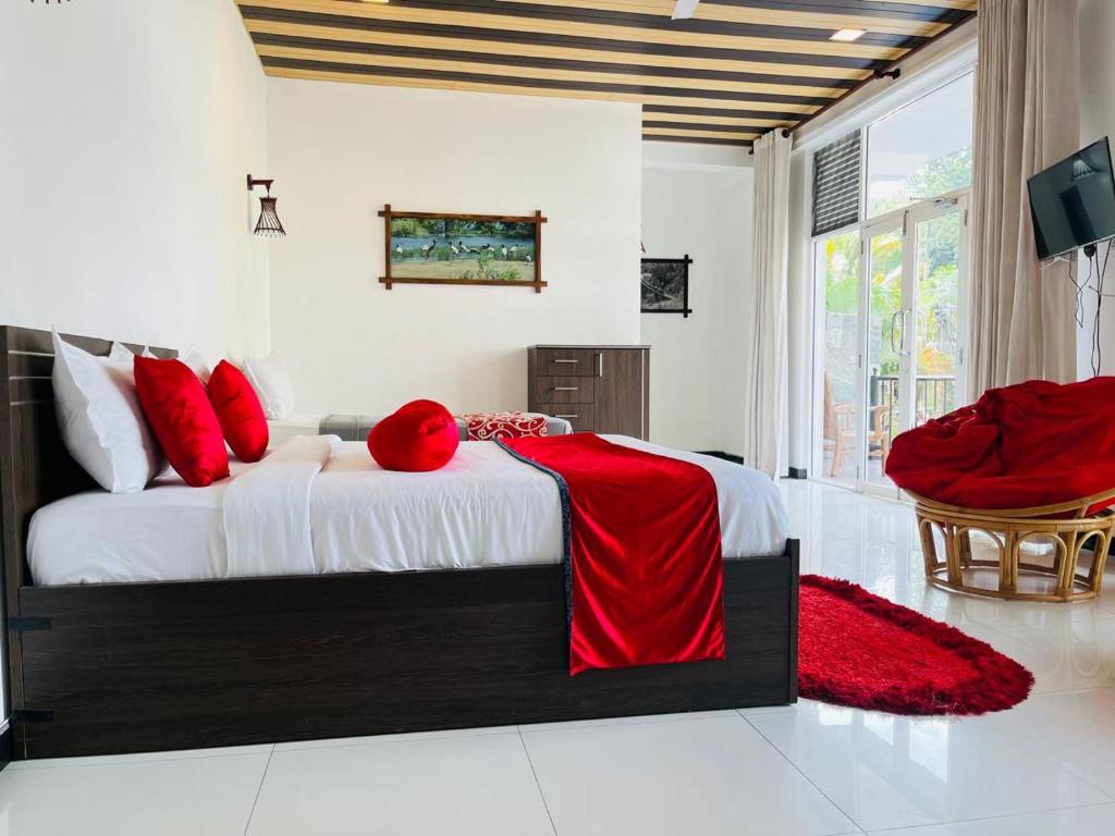 una camera da letto con un letto grande con cuscini rossi di New Sohili 3R Resort Ella a Ella