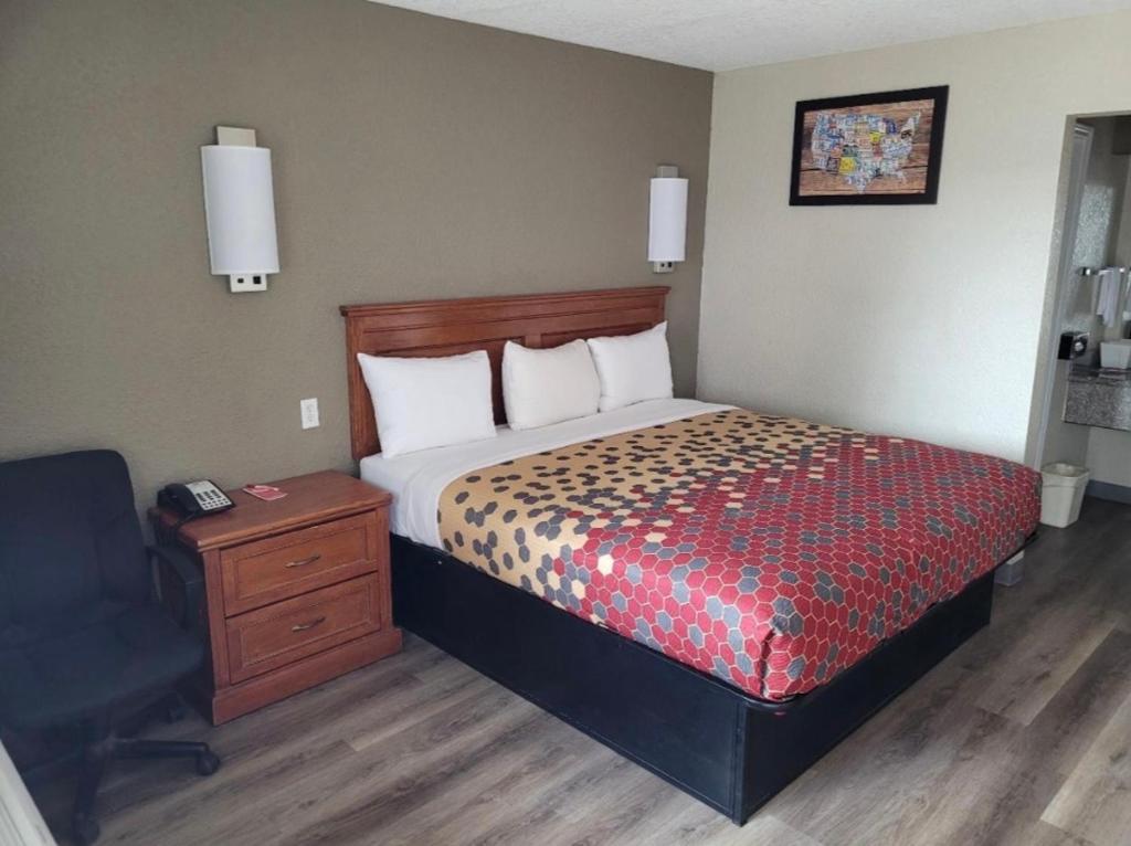 a bedroom with a bed and a desk and a chair at Econo Lodge Temple in Temple