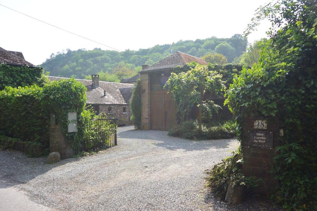 a driveway leading to a house with a wooden garage at L'arche De Noé in Dinant