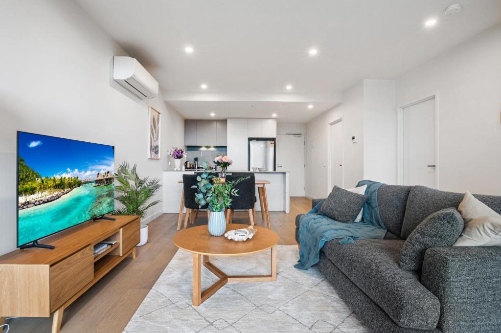 a living room with a couch and a tv at Heidelberg 2-Bed Retreat near Austin Hospital in Melbourne