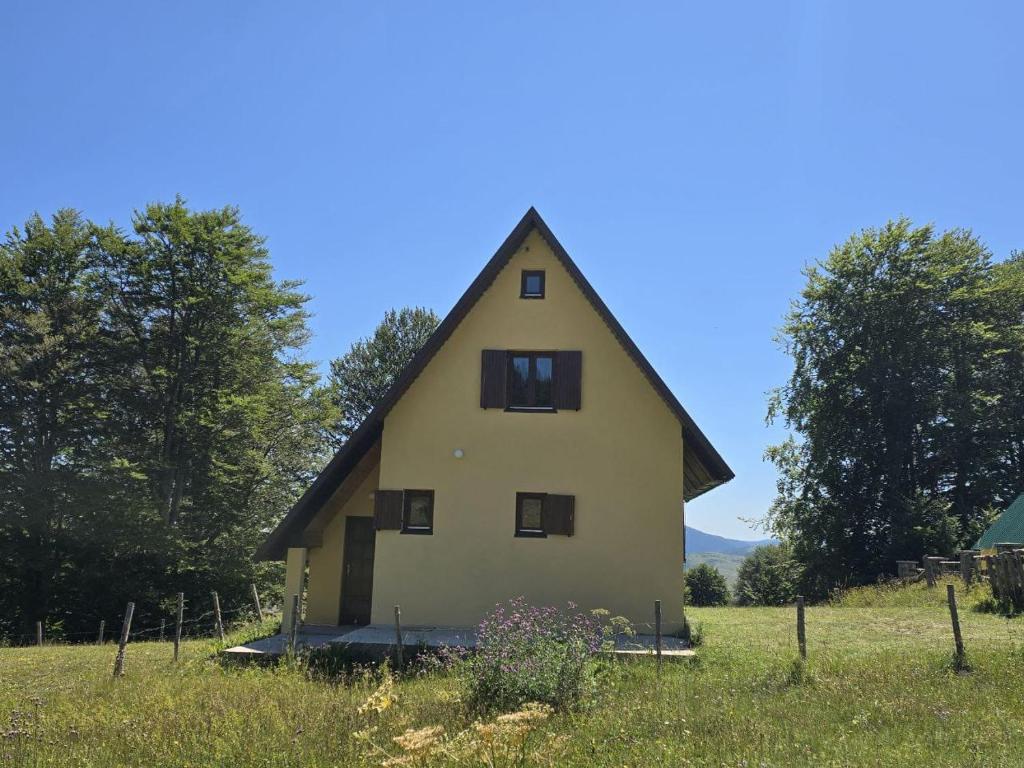 une maison avec un toit de chaume dans un champ dans l'établissement Enchanting chalet amidst impressive nature, à Žabljak