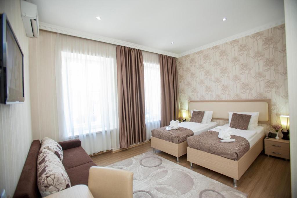 Habitación de hotel con 2 camas y sofá en Rustaveli Palace, en Tiflis