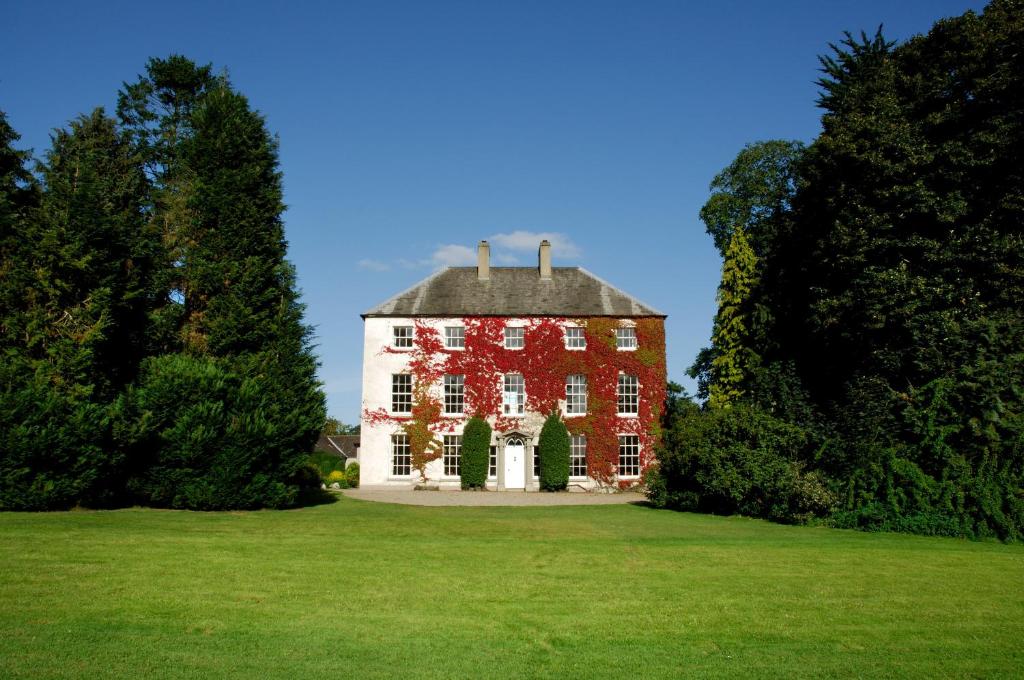 a large red and white house on a green field at Newforge House in Moira