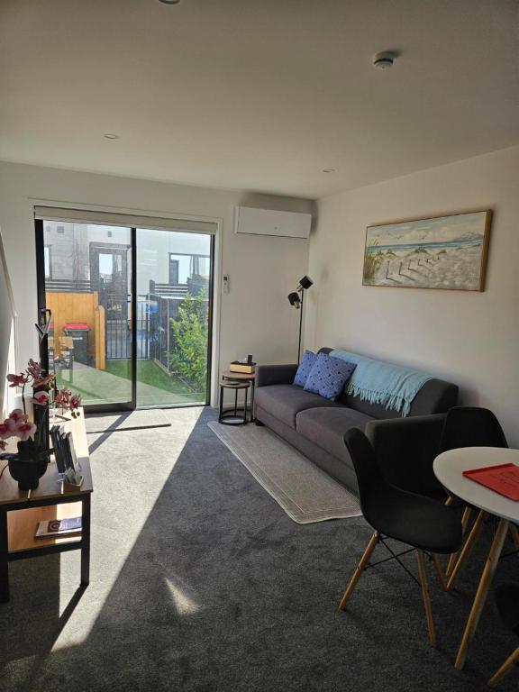una sala de estar con un sofá y una mesa en Beachside Townhouse, en Christchurch