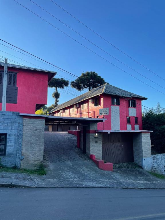 a pink building with a garage next to a street at Agha Motel in Canela