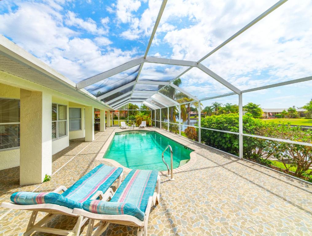 eine Person, die auf einer Chaiselongue neben einem Pool liegt in der Unterkunft House Rainbow in Cape Coral