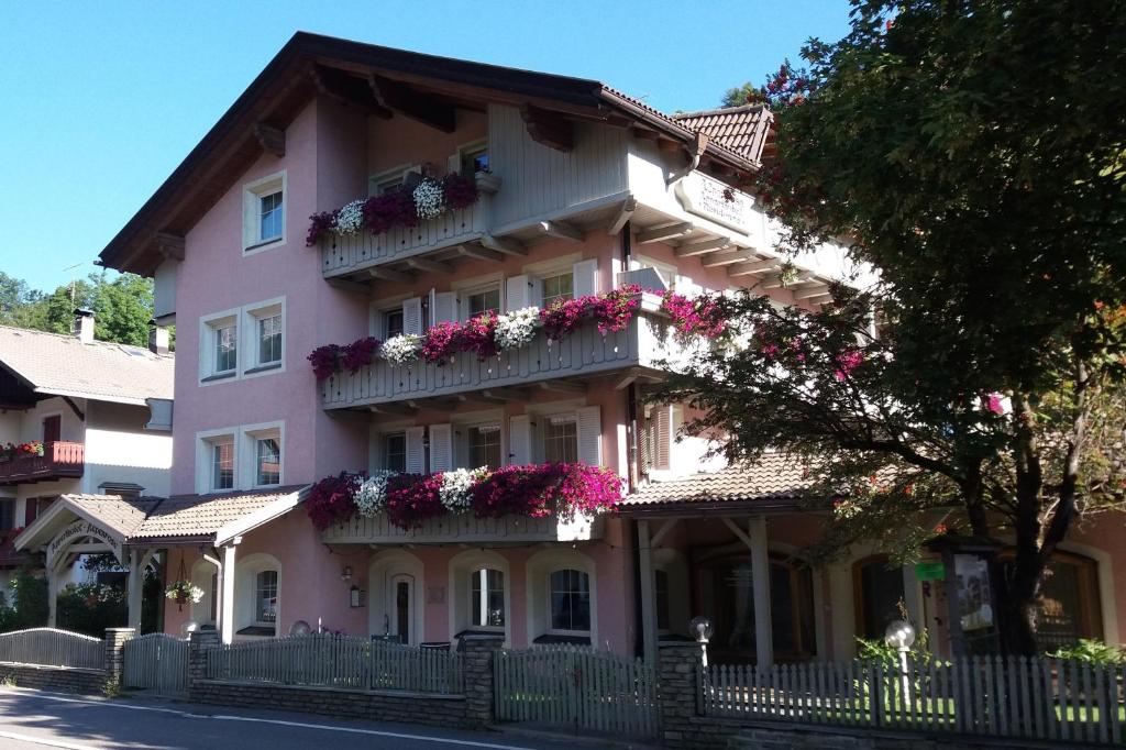 a pink building with flower boxes on it at Residence Alpenrose in Sesto