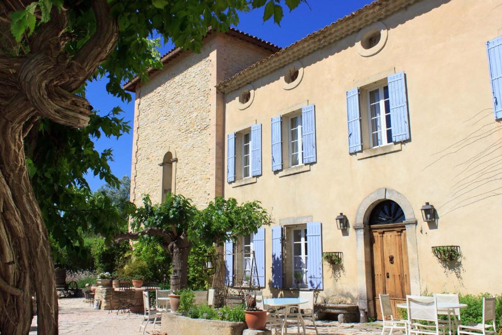 an old house with a tree in front of it at Les Carmes and spa in Le Thor