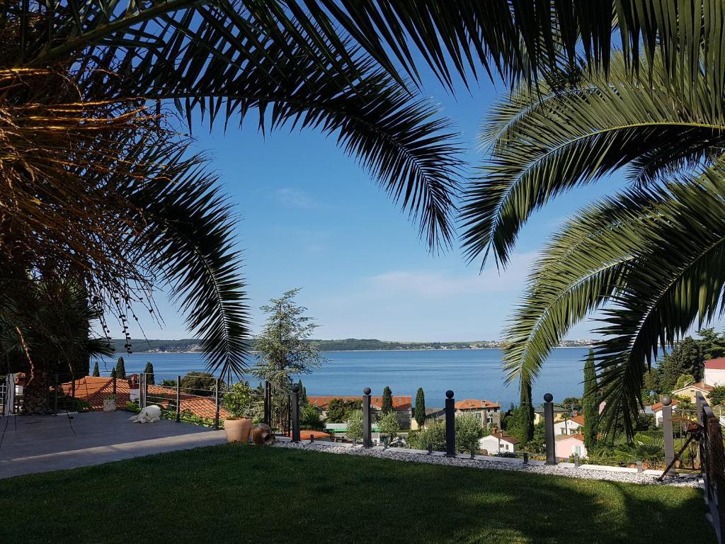 a view of the water from a resort with palm trees at Studio-apartments Monfort in Portorož