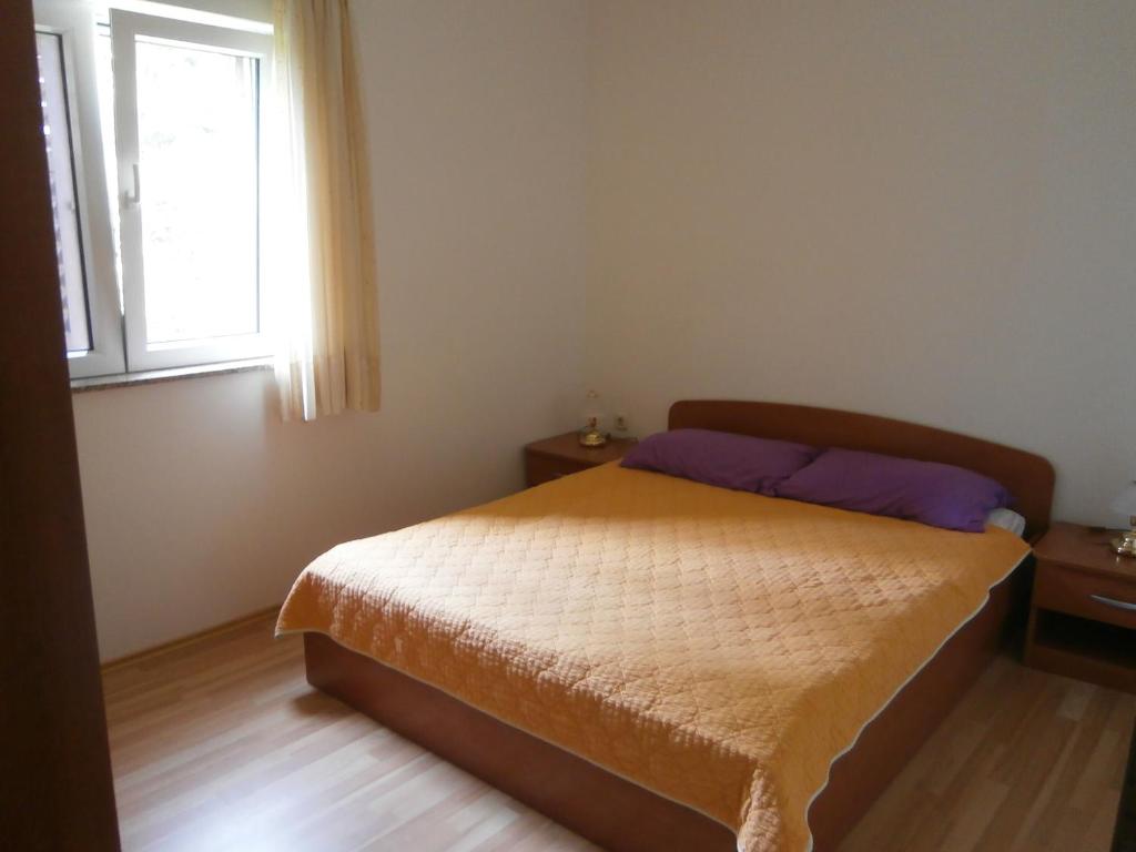 Schlafzimmer mit einem Bett und einem Fenster in der Unterkunft Apartment Maglica in Zlarin