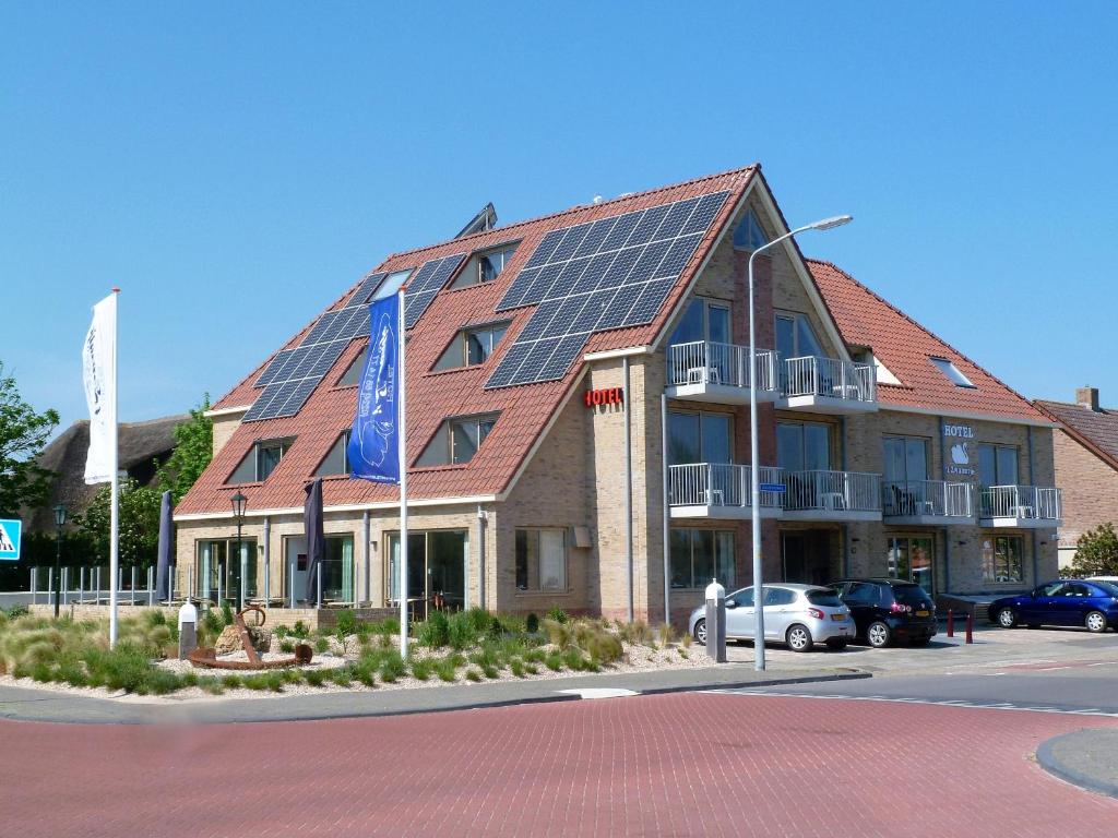 カラントスウオーフにあるHotel het Zwaantjeの屋根の太陽光パネル付き建物