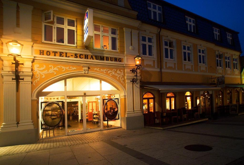 un edificio hotelennaenna con un arco en una calle por la noche en Hotel Schaumburg en Holstebro