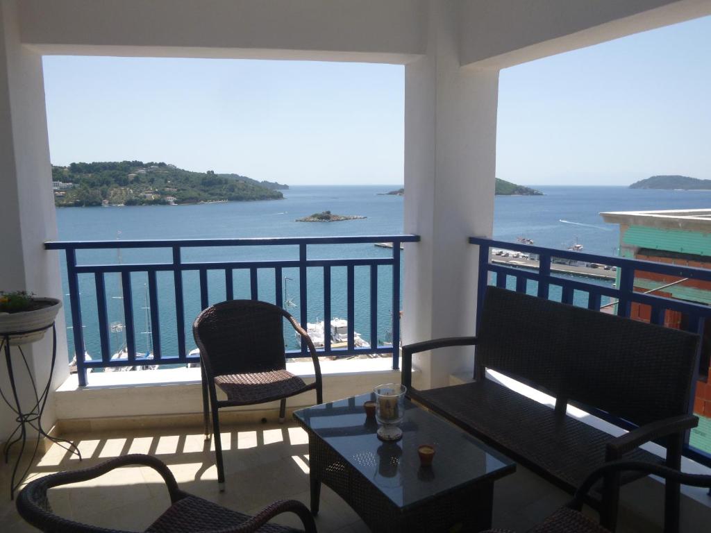 a balcony with a table and chairs and a view of the ocean at Paradisos House in Skiathos