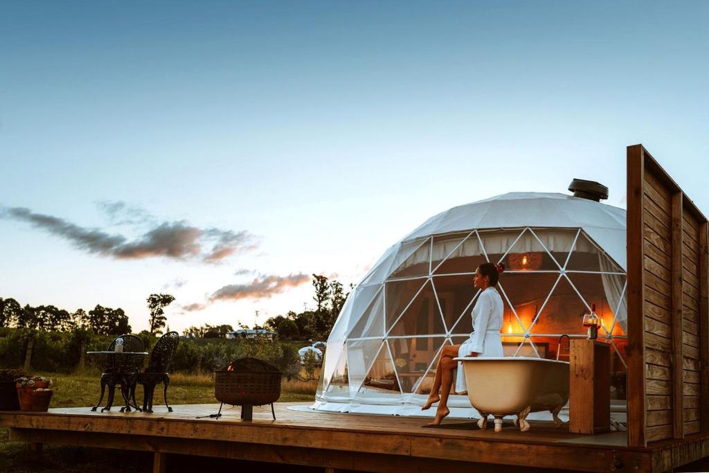 a woman standing in a bath tub in a domed dome at Bespoke Dome Perfect for a Couples Getaway in Tasmania in Sidmouth