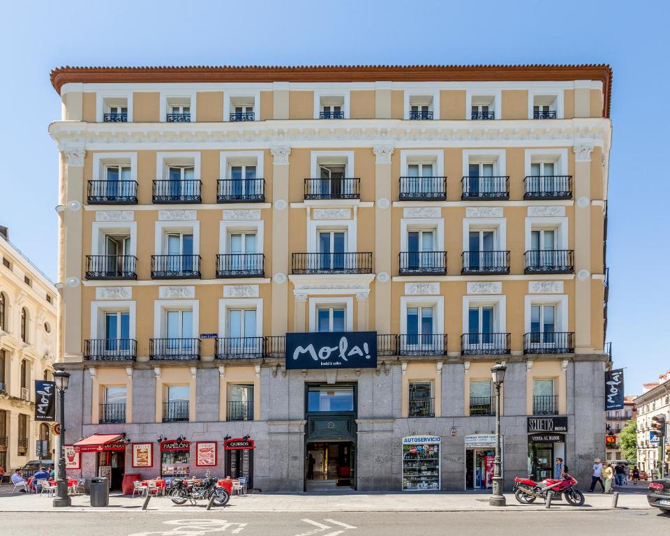 un gran edificio amarillo con un cartel. en Mola Hostel, en Madrid