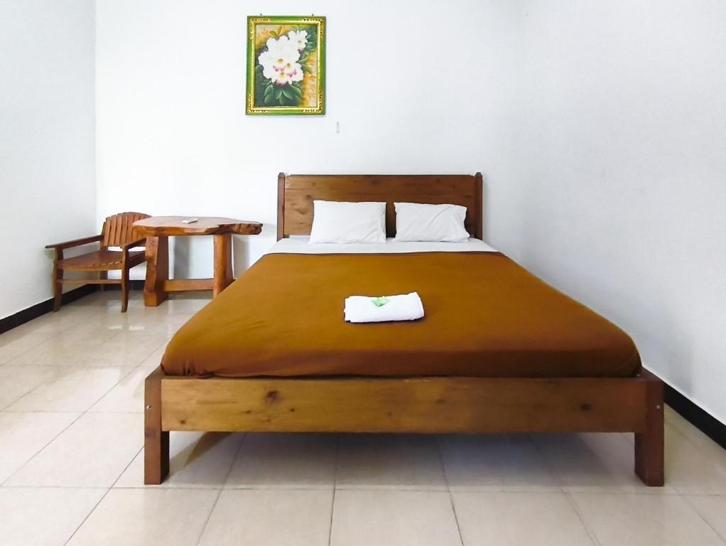 une chambre avec un lit et une table avec une chaise dans l'établissement The Semeton Homestay Senggigi RedPartner, à Montongbuwoh