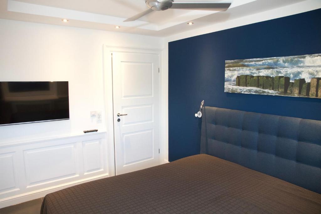 um quarto com uma cama e uma televisão na parede em Tag am Meer Sylt II em Westerland
