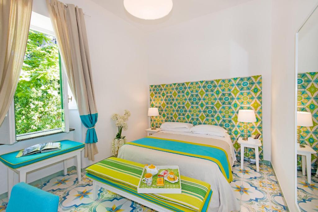 a bedroom with a bed and a table and a window at Relais Correale Rooms & Garden in Sorrento