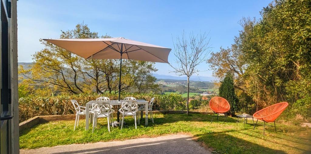 a table and chairs with an umbrella on the grass at Casa Cotera in Sierra