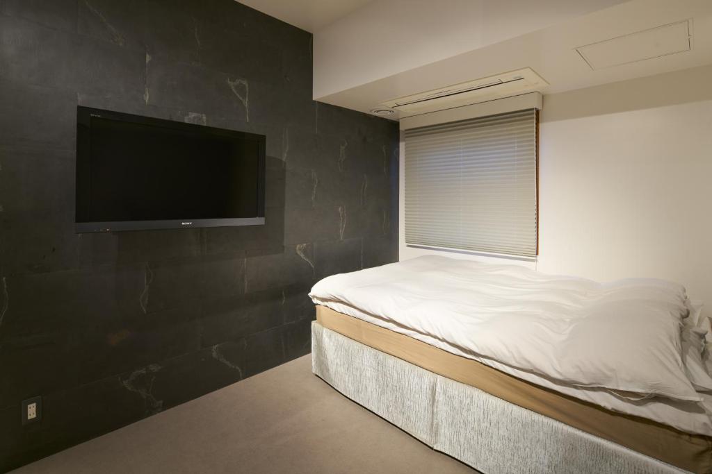 Tempat tidur dalam kamar di Shinjuku City Hotel N.U.T.S Tokyo