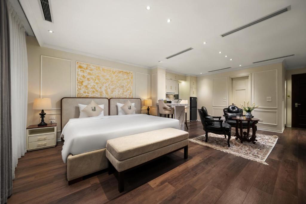 a bedroom with a large white bed and a table at Jade Boutique Hotel in Hanoi